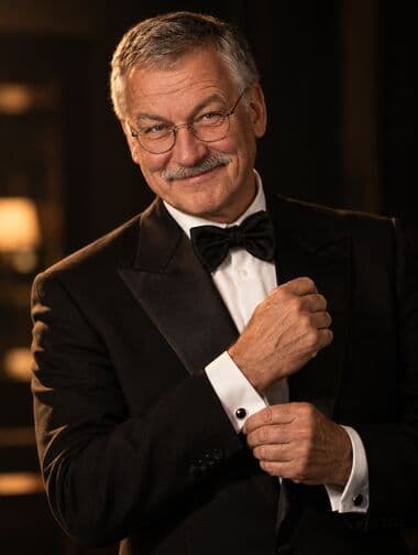 Werner im Smoking, halbnah im Spionagefilm-Licht